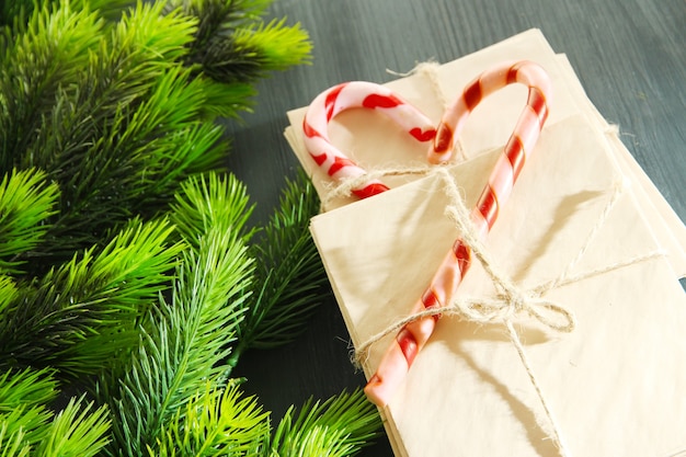 Bastones de caramelo de Navidad y cartas para Santa, sobre fondo de madera de color