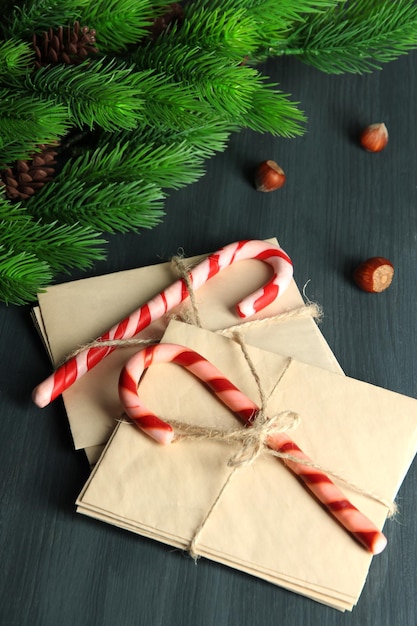 Bastones de caramelo de Navidad y cartas para Santa, sobre fondo de madera de color