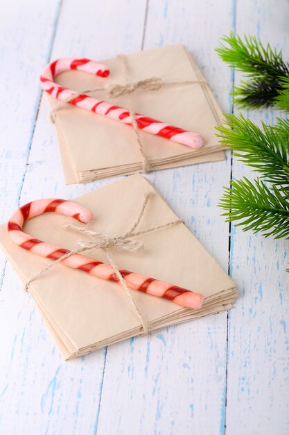 Bastones de caramelo de Navidad y cartas para Santa, sobre mesa de madera de color