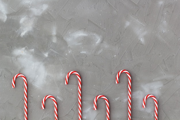 Bastones de caramelo rojos y blancos aislados en gris