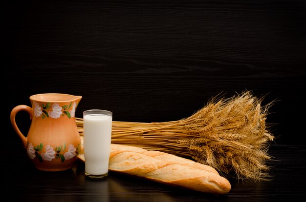 Bastones, una jarra, un vaso de leche y una gavilla