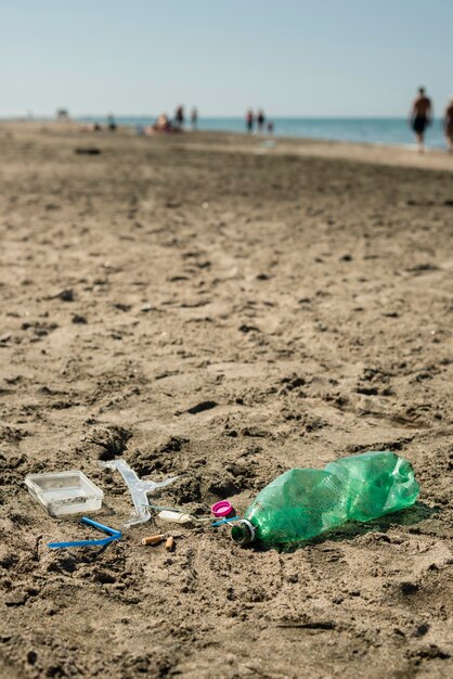 Basura plástica dejada en una playa de arena