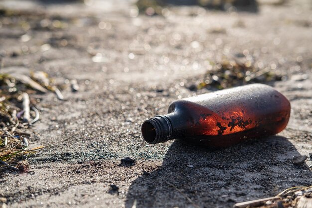 Foto basura en la playa botella en la arena en un día soleado contaminación ambiental basura humana