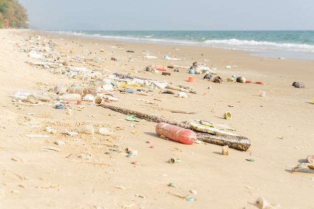 Basura en la playa tropical. Problema ambiental de contaminación plástica. Botellas de plástico y otra basura varada en la playa.