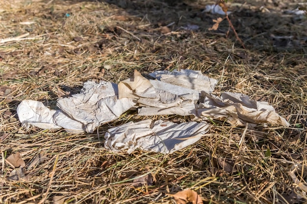 Basura sucia del papel higiénico en la naturaleza en la hierba