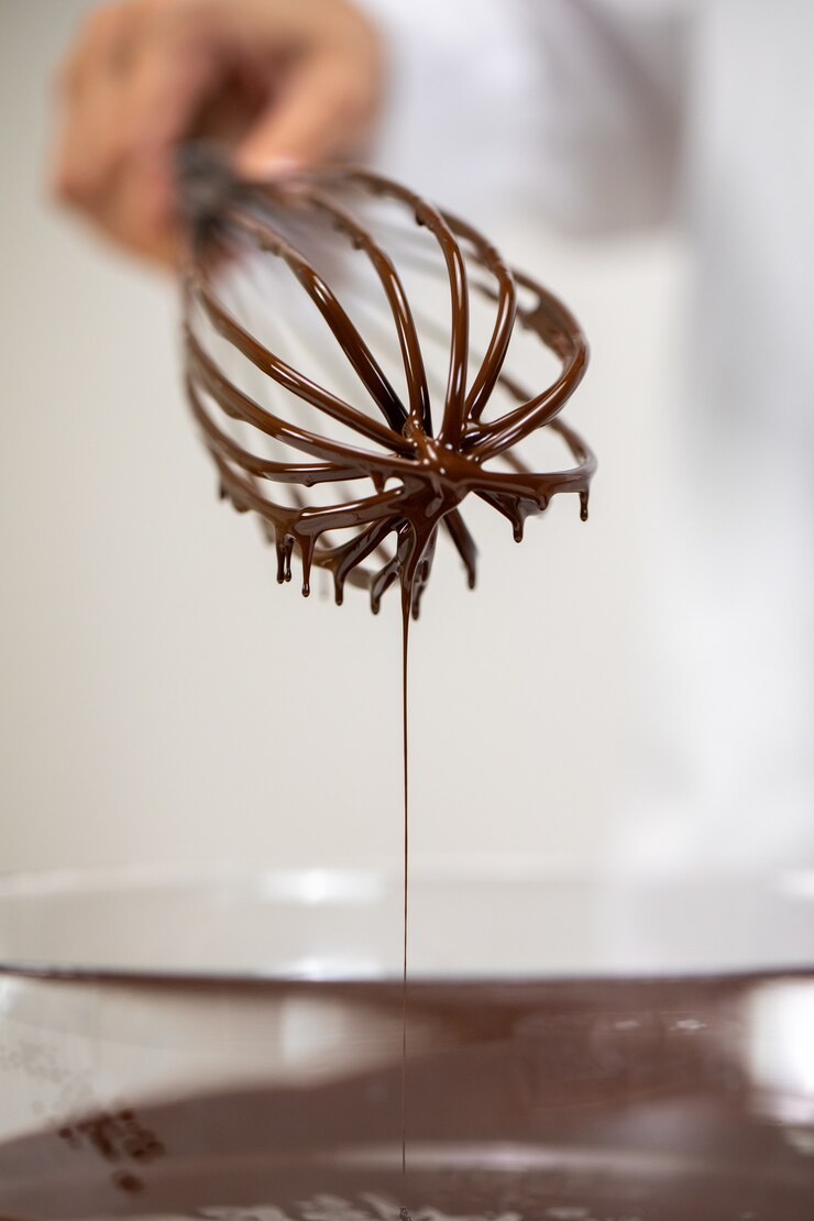 Foto bata tirada de chocolate amargo belga quente derretido