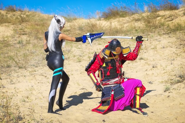 Batalla de dos personajes: un hombre disfrazado de samurái con espada y una niña del futuro con espada. Cosplay original.