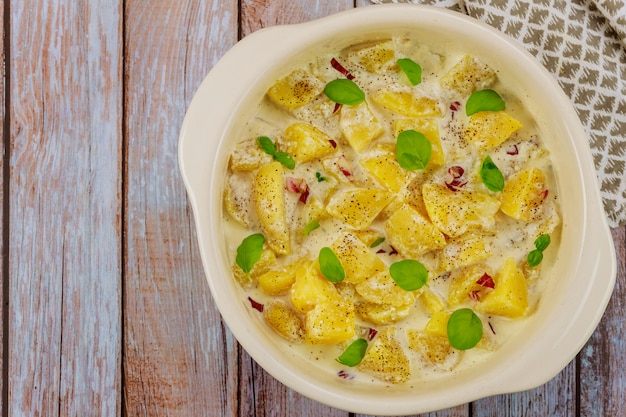 Foto batata assada na tigela do forno com molho cremoso