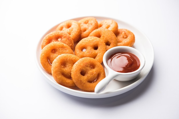 Batata crocante de batatas fritas com cara sorridente ou salgadinhos com cara de sorriso frito servidos com ketchup