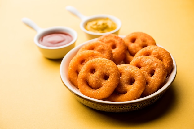 Batata crocante de batatas fritas com cara sorridente ou salgadinhos com cara de sorriso frito servidos com ketchup