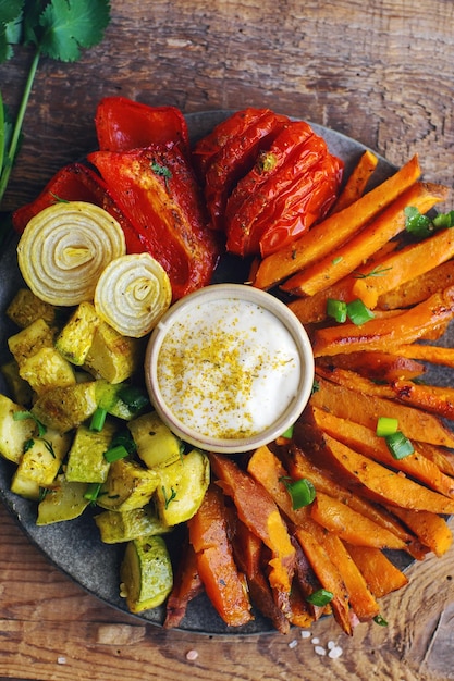 Batata-doce assada no forno caseiro com tomate cebola pimenta vermelha e molho no fundo rústico conceito de alimentação saudável vista superior