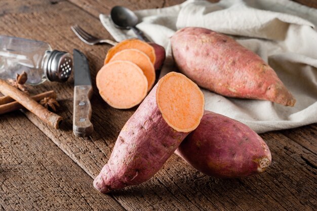 Batata doce crua em uma mesa de madeira