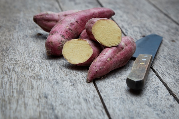 Batata-doce crua no fundo de madeira