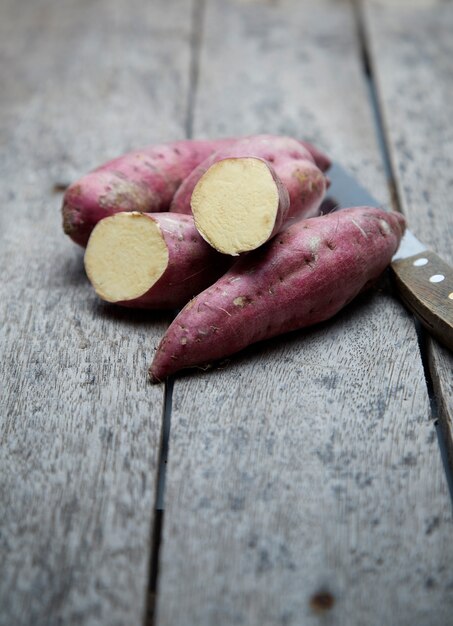 Batata-doce crua no fundo de madeira