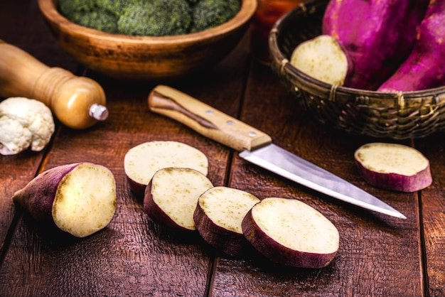 Batata-doce fatiada em tubérculo de mesa de madeira rústica chamado terra batata ilha batata jatica e jetica usado como ingrediente culinário