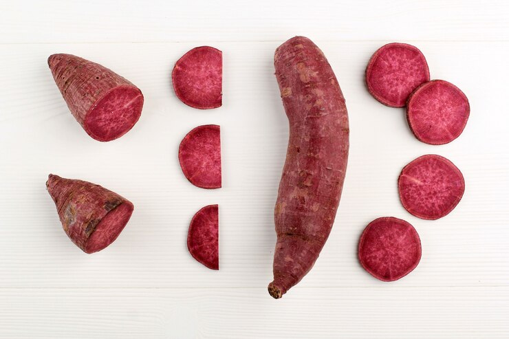 Foto batata doce japonesa vermelha roxa em várias fatias sobre fundo branco