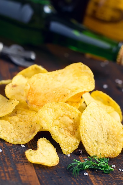 Batata frita com verduras na garrafa de cerveja de fundo.