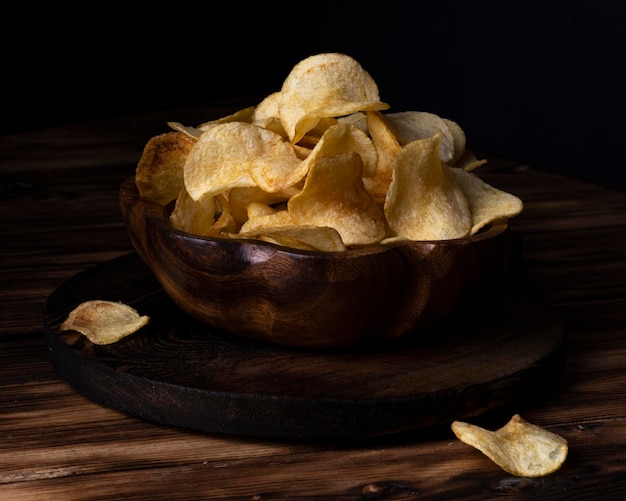 Batata frita em uma tigela de madeira sobre um fundo de madeira