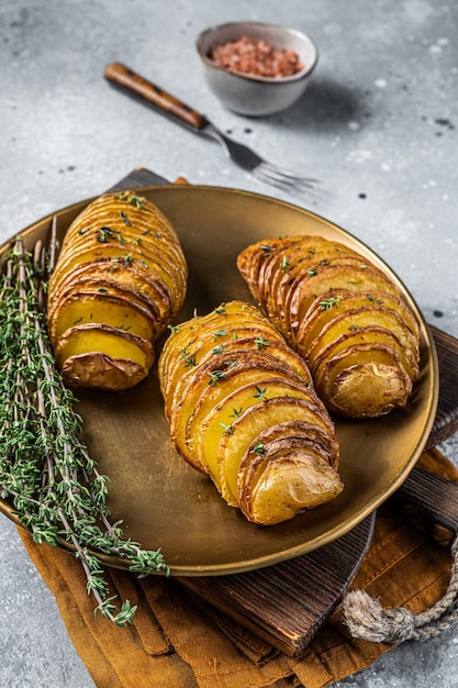 Batata Hasselback assada com tomilho fresco e alecrim Fundo cinza Vista superior