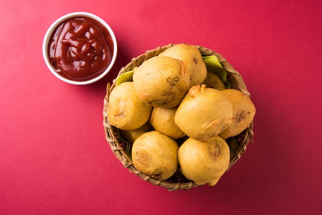 Batata Vada ou Aloo Bonda é um lanche da hora do chá indiano saboroso e popular servido com pimenta verde e ketchup de tomate. Foco seletivo