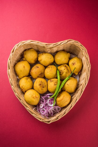 Batata Vada ou Aloo Bonda é um lanche da hora do chá indiano saboroso e popular servido com pimenta verde e ketchup de tomate. Foco seletivo