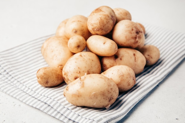 Batatas agrícolas jovens. Batata crua em uma mesa.