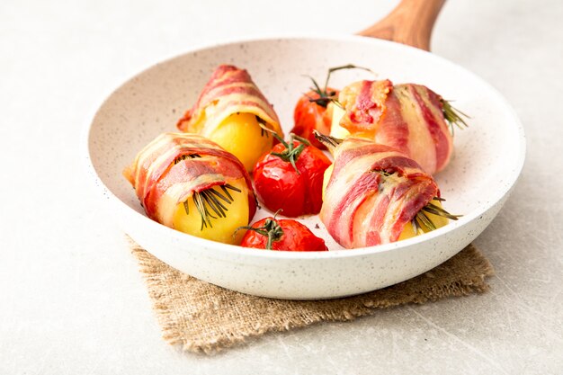 Batatas assadas com bacon, tomate e alecrim.