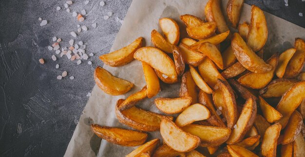 Batatas assadas, lanches em um fundo escuro