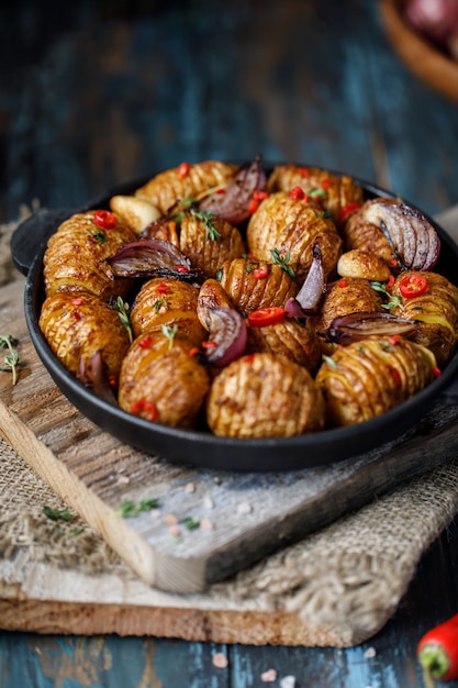 Batatas assadas na panela de ferro fundido com cebola, alho e ervas