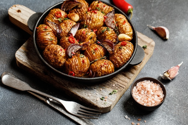 Batatas assadas na panela de ferro fundido com cebola, alho e ervas