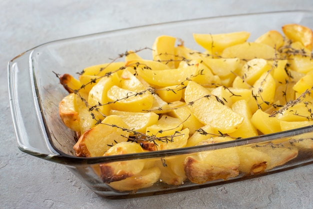 Batatas assadas no forno com azeite, alho e tomilho em forma de vidro.