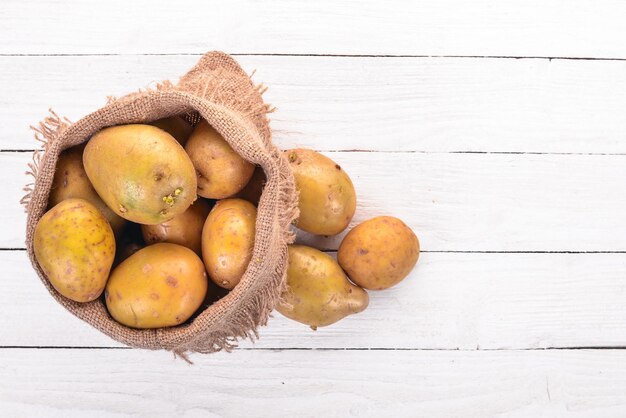 Batatas cruas Em um fundo branco Cozinhar Espaço livre para texto Vista superior