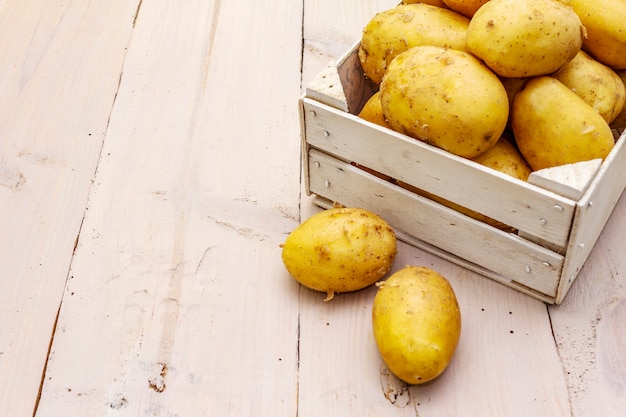 Batatas cruas frescas em caixa de madeira