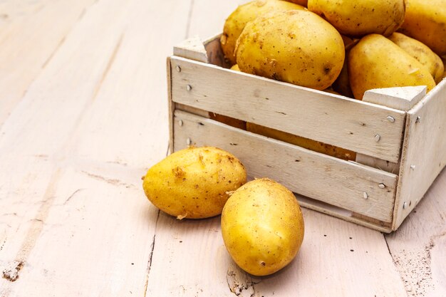 Batatas cruas frescas em caixa de madeira