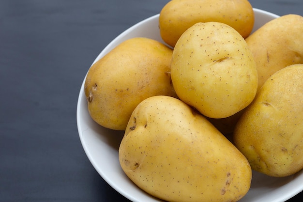 Batatas cruas isoladas em fundo escuro