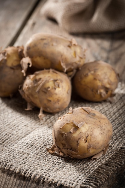 Batatas cruas na mesa de madeira