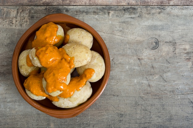 Batatas das Canárias (papas arrugadas) com molho mojo na mesa de madeira