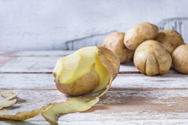 Foto batatas descascadas em fundo de madeira