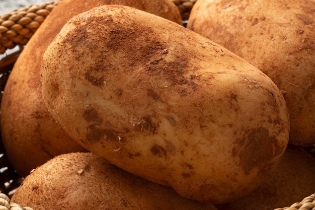 Batatas francesas colhidas frescas com argila em uma cesta fechada