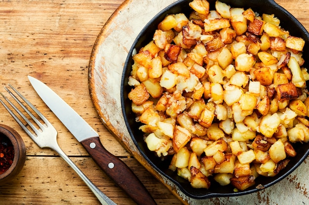 Batatas fritas apetitosas. Batatas assadas na assadeira de ferro fundido