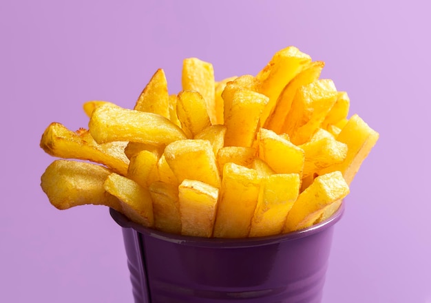 Foto batatas fritas closeup alimentos fritos batatas fritas em fundo roxo