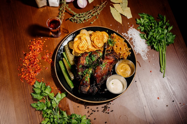 Batatas fritas com carne em um prato sobre uma mesa de madeira.