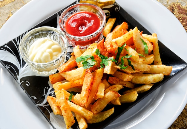 Batatas fritas com dois molhos diferentes.