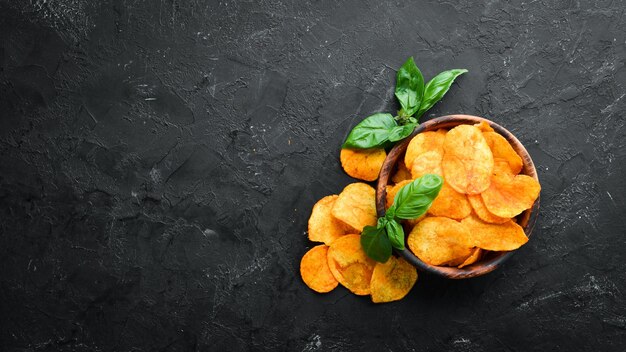 Batatas fritas com especiarias em um fundo preto Lanches para cerveja Vista superior Espaço livre para texto