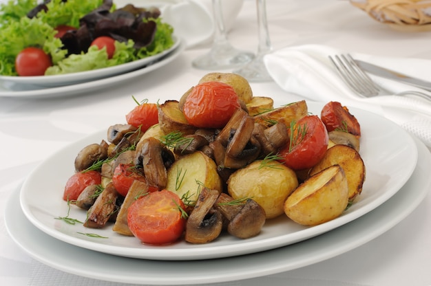 Batatas fritas com fatias de cogumelos e tomates