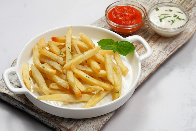 batatas fritas com maionese e molho de pimenta no fundo branco