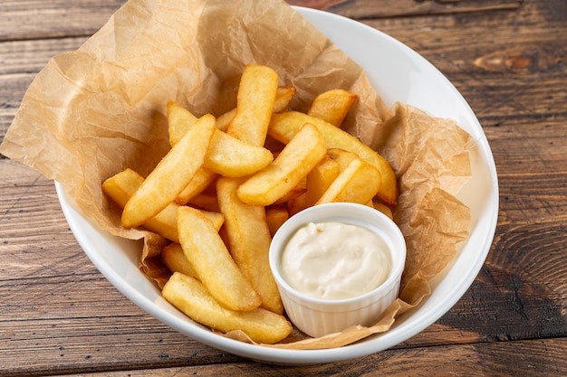 Batatas fritas com molho em um prato branco