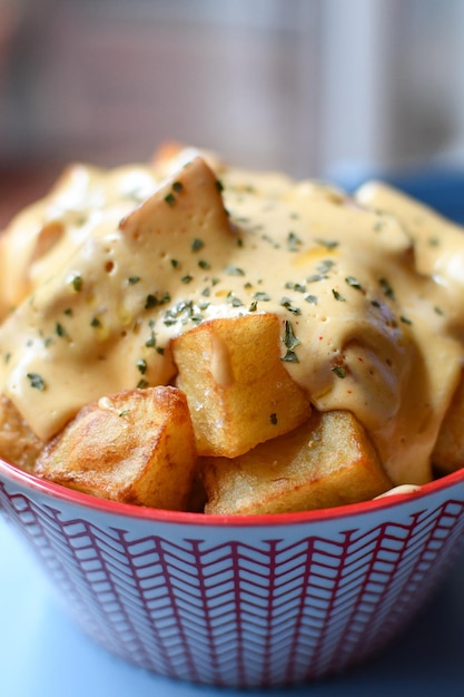 Batatas fritas com molho picante em uma tigela vermelha