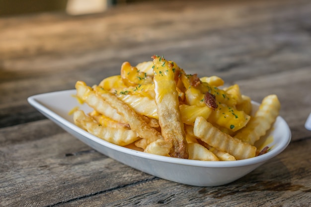 Batatas fritas com queijo em cima da mesa