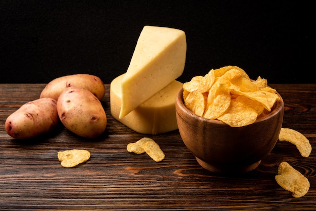 Batatas fritas com queijo na mesa de madeira